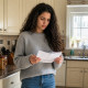 Woman looking puzzled at a signed permission slip in a kitchen