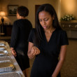 Mara at the funeral home looking at a bent-ring key as Aunt Darlene walks away.