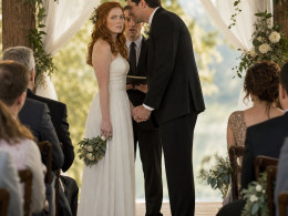 At the altar, the redheaded bride stands tense as the groom leans in smiling, gripping her hand too tightly while the officiant looks startled.