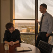 After-hours in a glass-walled conference room, Graham lowers the blinds while Iris looks up from the table, tense.