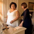 In a bridal suite, the bride stares at a sealed envelope as her future mother-in-law locks the door.