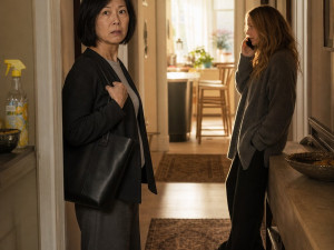 A woman freezes in the hallway while a blonde houseguest talks on someone else’s phone.
