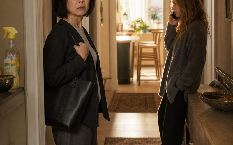 A woman freezes in the hallway while a blonde houseguest talks on someone else’s phone.