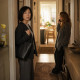 A woman freezes in the hallway while a blonde houseguest talks on someone else’s phone.