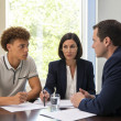 Mara and her lawyer stare at Evan across a mediation table as he tightens his jaw over paperwork.